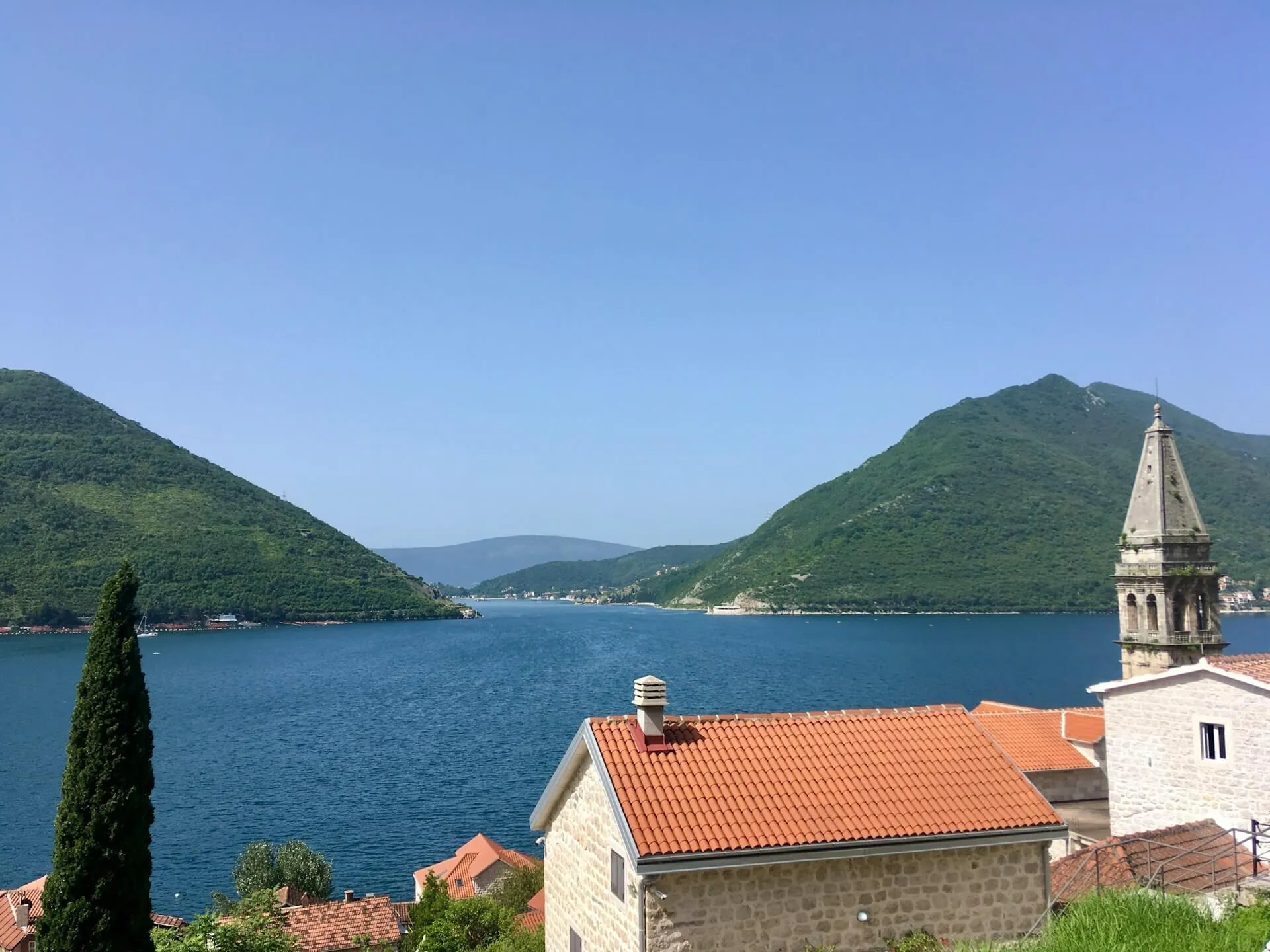 Blick auf eine Inselkirche in Montenegro mit Meer und Bergen – Inspiration für den Hausbau