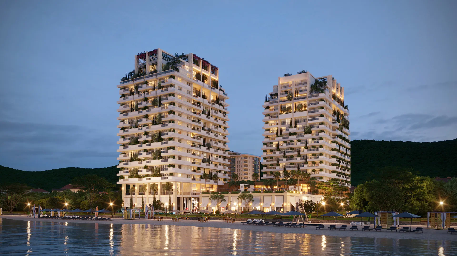 Zwei Wohntürme mit Hotel direkt am Strand von Budva in der Abenddämmerung